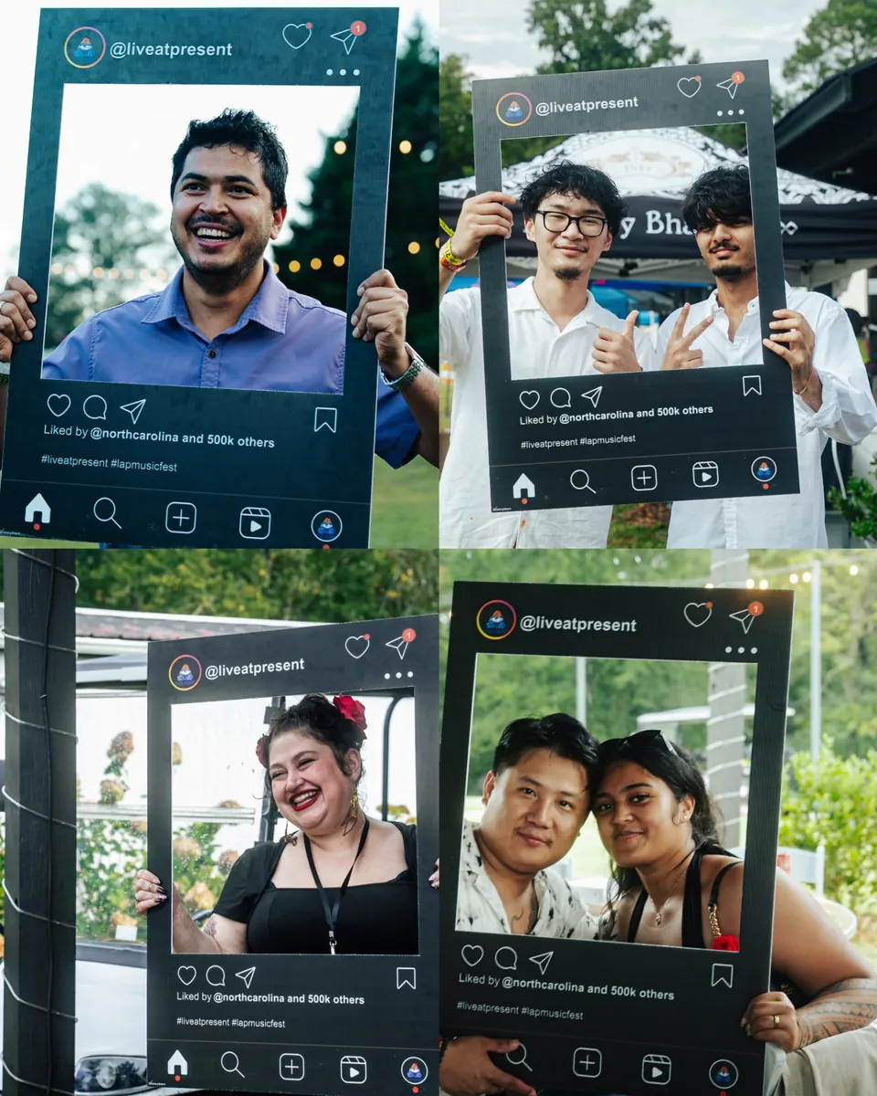 Smiling festival guests posing with the Live At Present photo frame